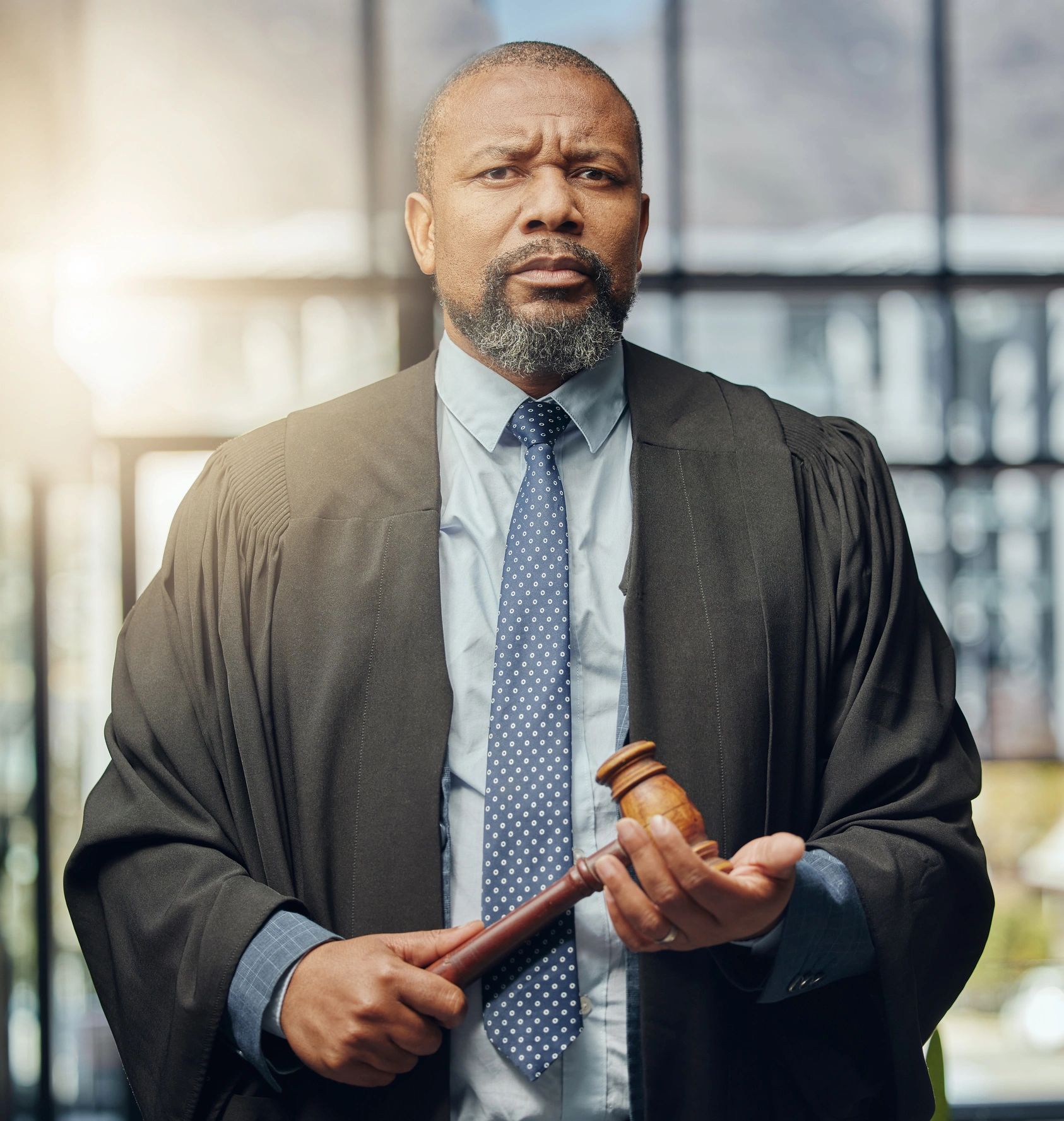 Confident judge holding a gavel in a courtroom.