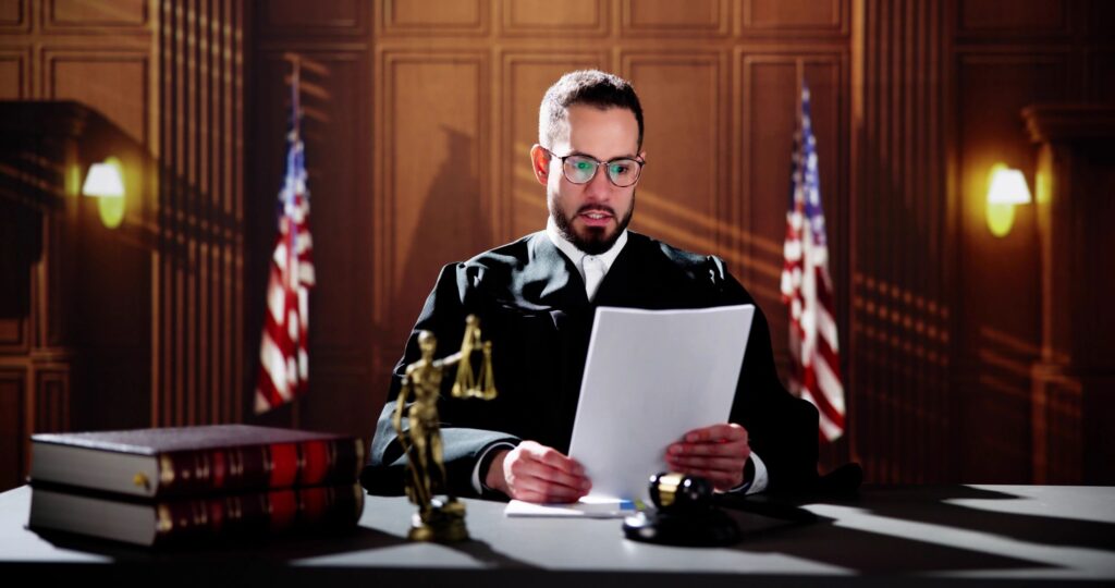 Judge reading a document in courtroom.